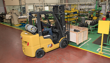Man Using a Cat Cushion Tire Internal Combustion Forklift to Lift a Load